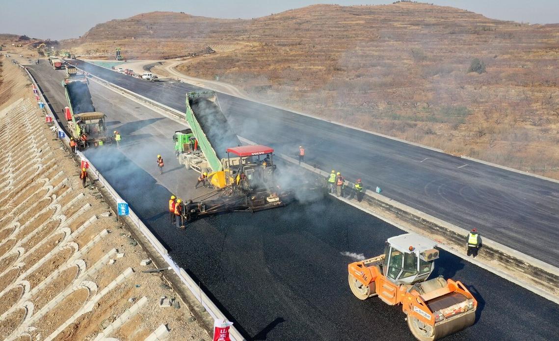 山东临沂至滕州高速公路路面工程沥青摊铺施工 现场一派繁忙