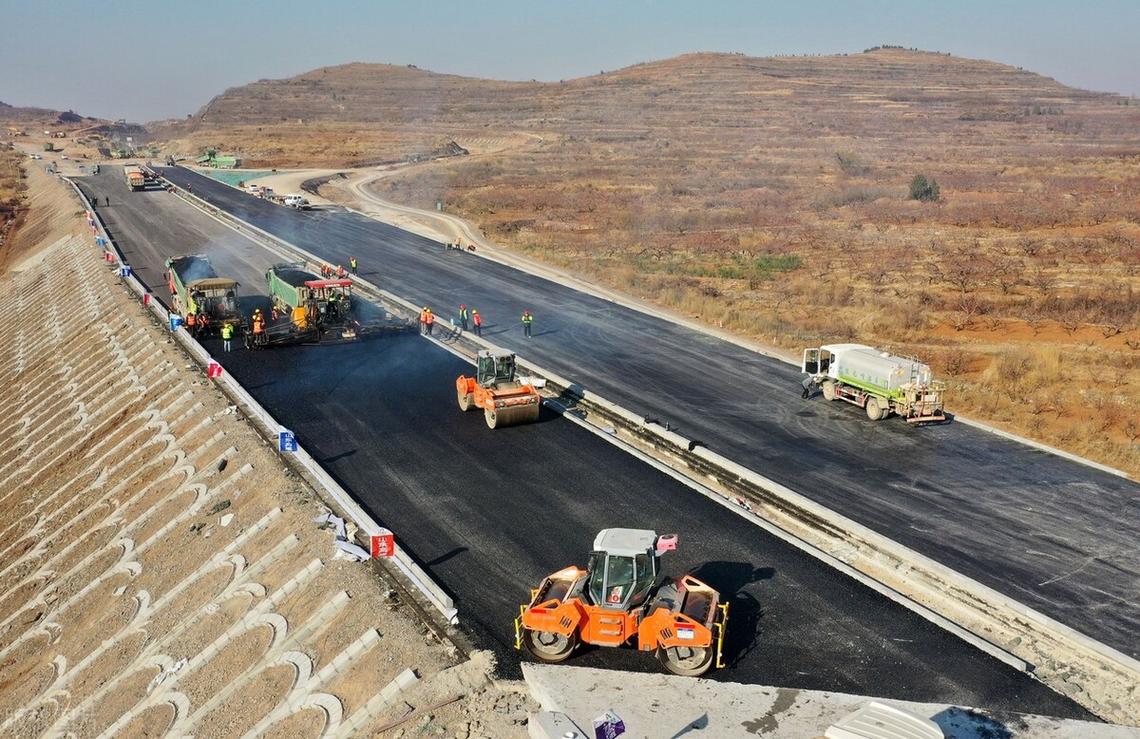 山东临沂至滕州高速公路路面工程沥青摊铺施工 现场一派繁忙